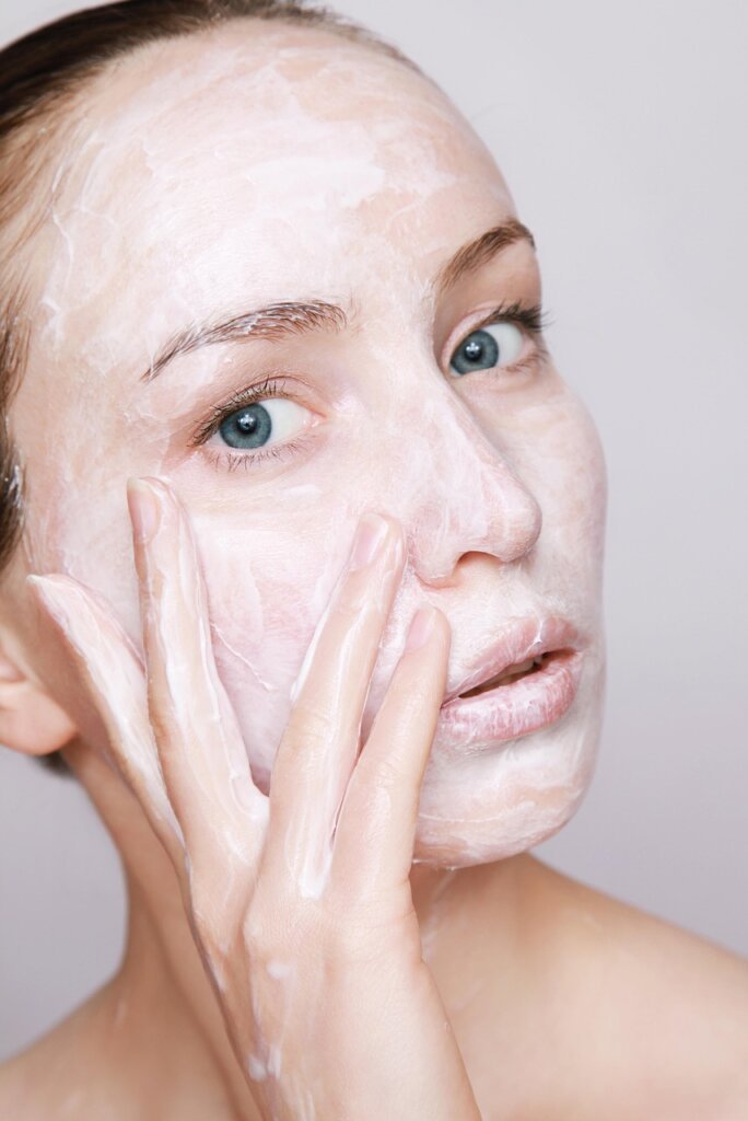 person applying lemon eucalyptus lotion on forearm before going outside in summer evening