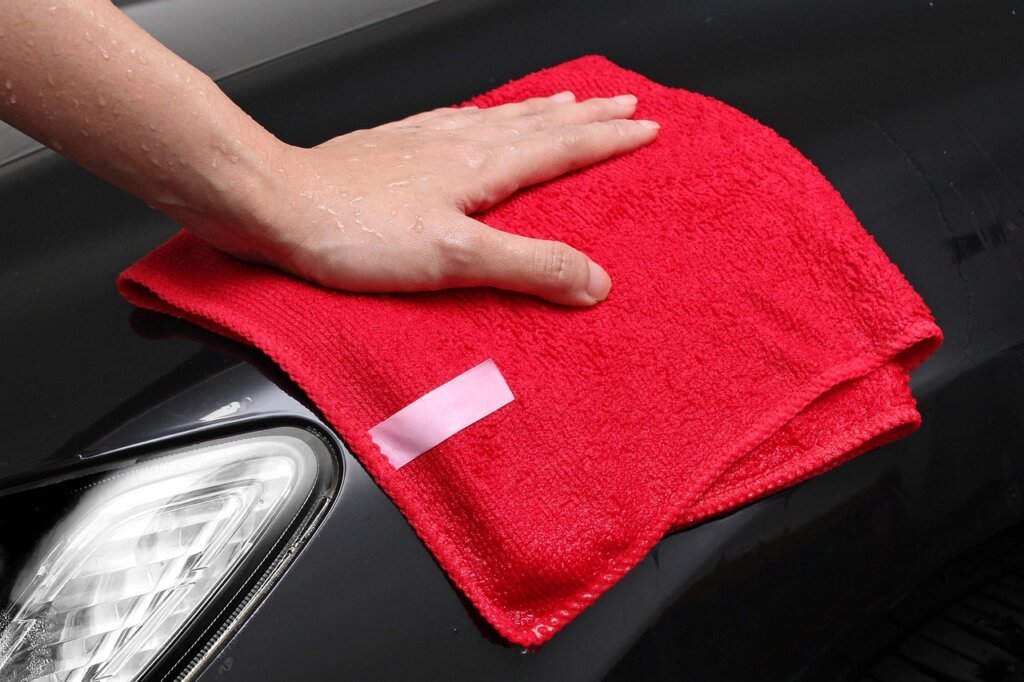 hand holding microfiber cloth wiping inside of air fryer