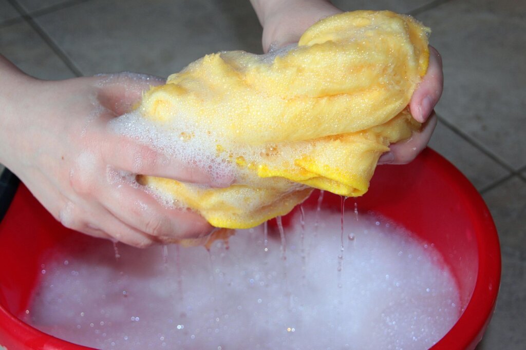 cleaning fan blades with old toothbrush and soapy cloth