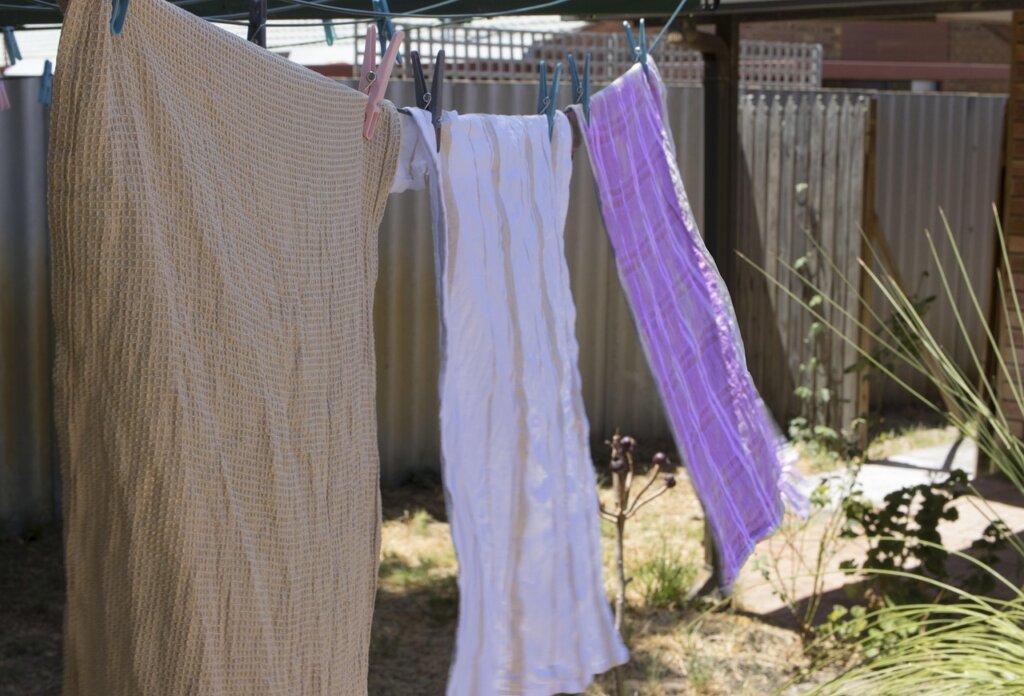 hand shaking damp towel vigorously before hanging