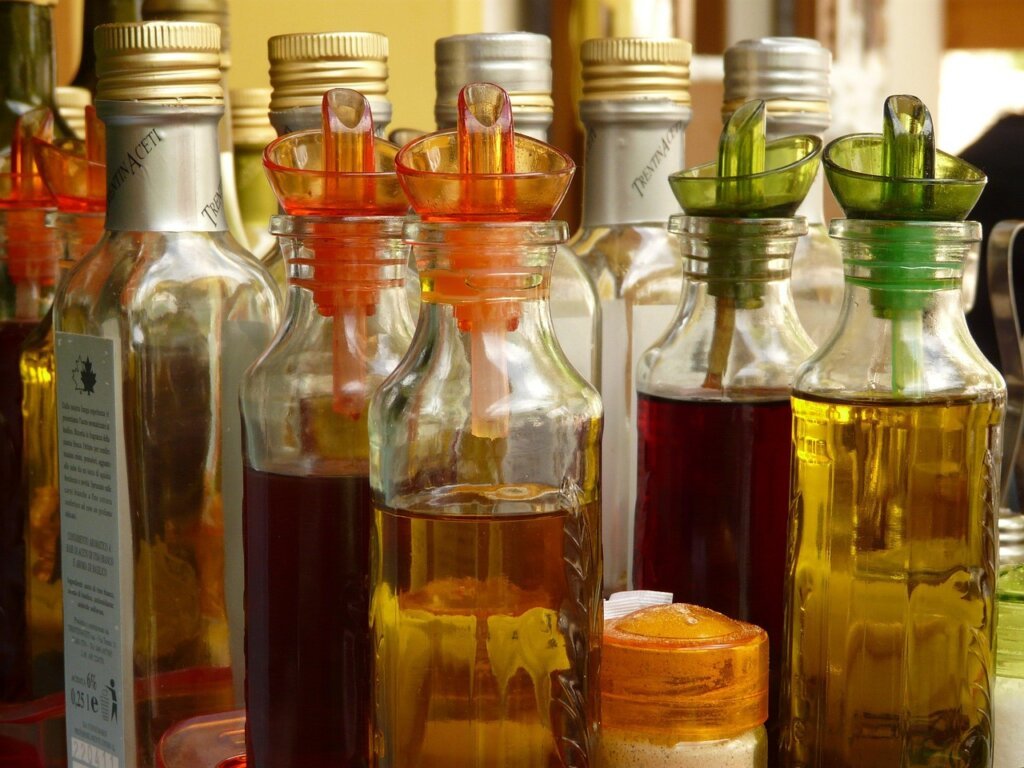 white vinegar bottle with measuring cup and water