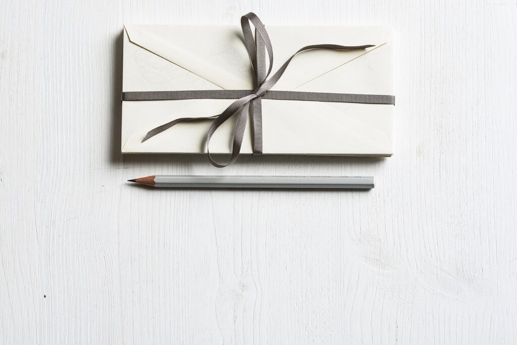 clean white paper envelope with folded kf94 mask on wooden table