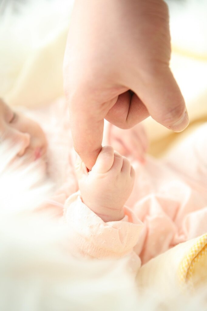 Korean parents with newborn baby at home, warm family scene