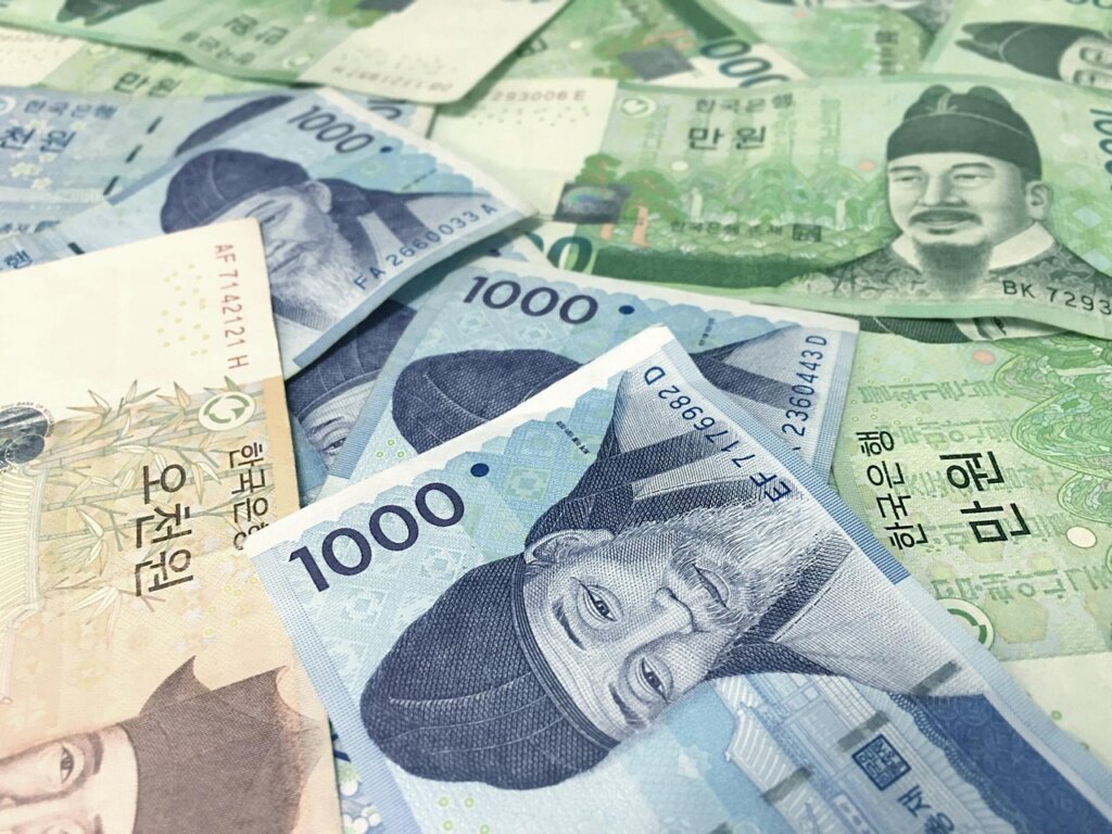 korean won banknotes and coins on wooden table representing financial support
