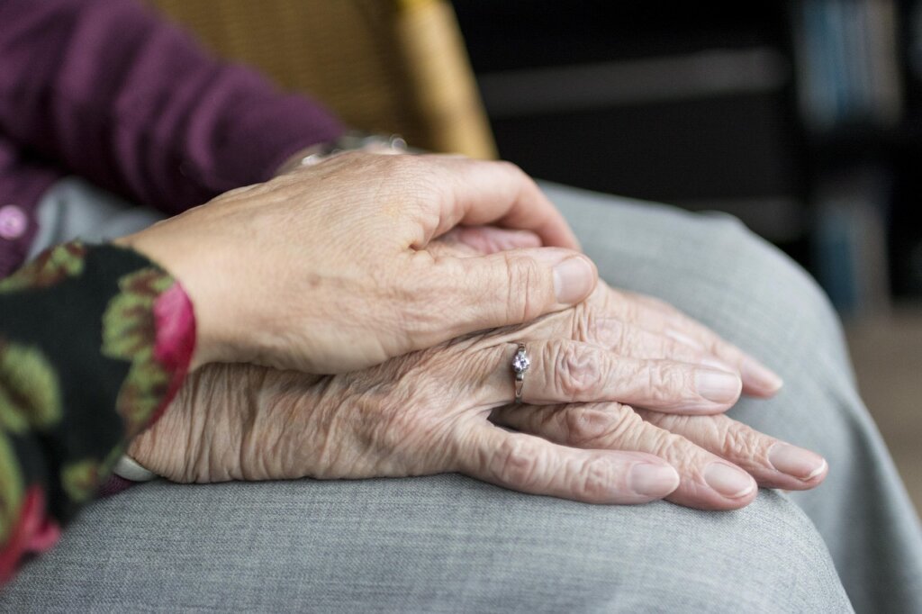 Korean family member helping elderly parent fill out paperwork at government office