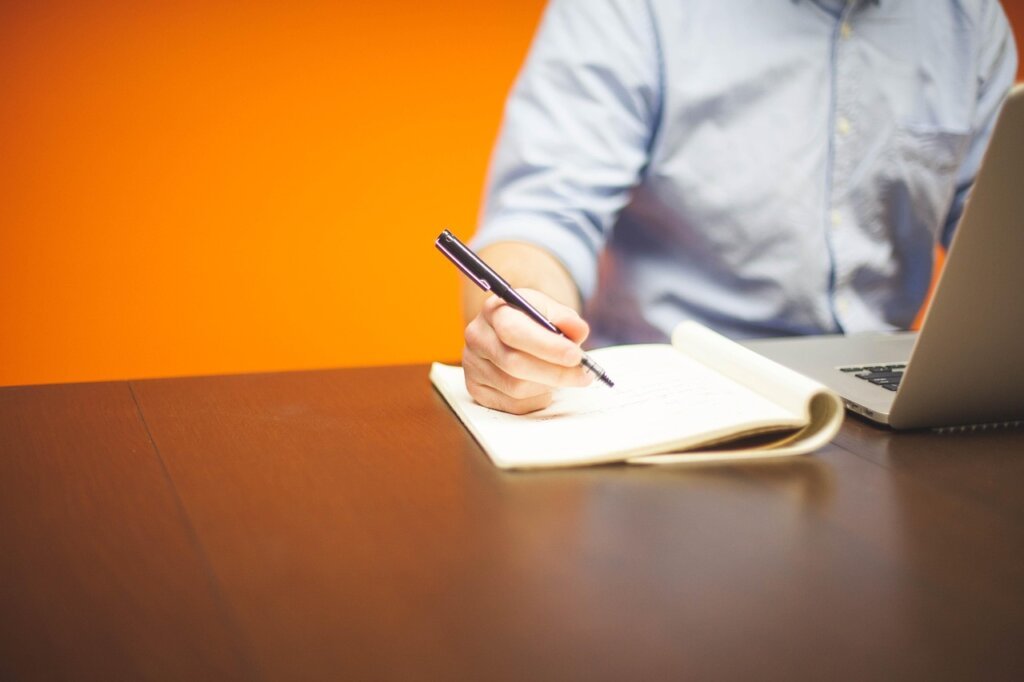 freelance designer working at computer with financial documents