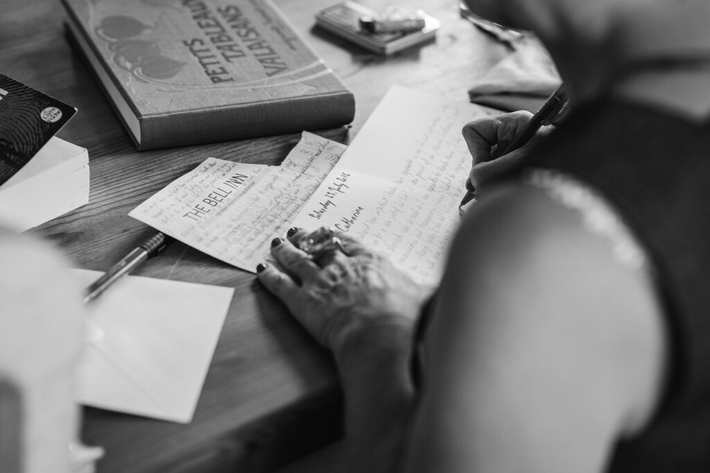 journal with handwritten notes and a pen beside a window with natural light