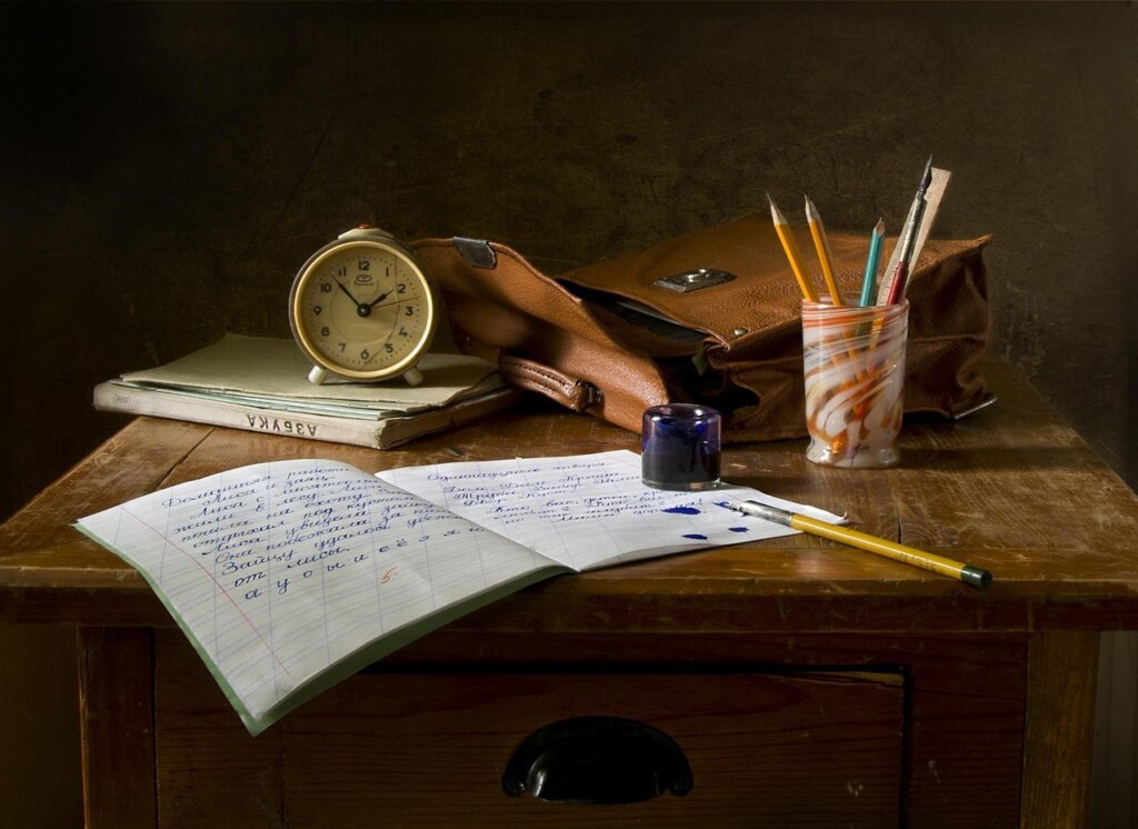calculator and school expense notebook on wooden desk