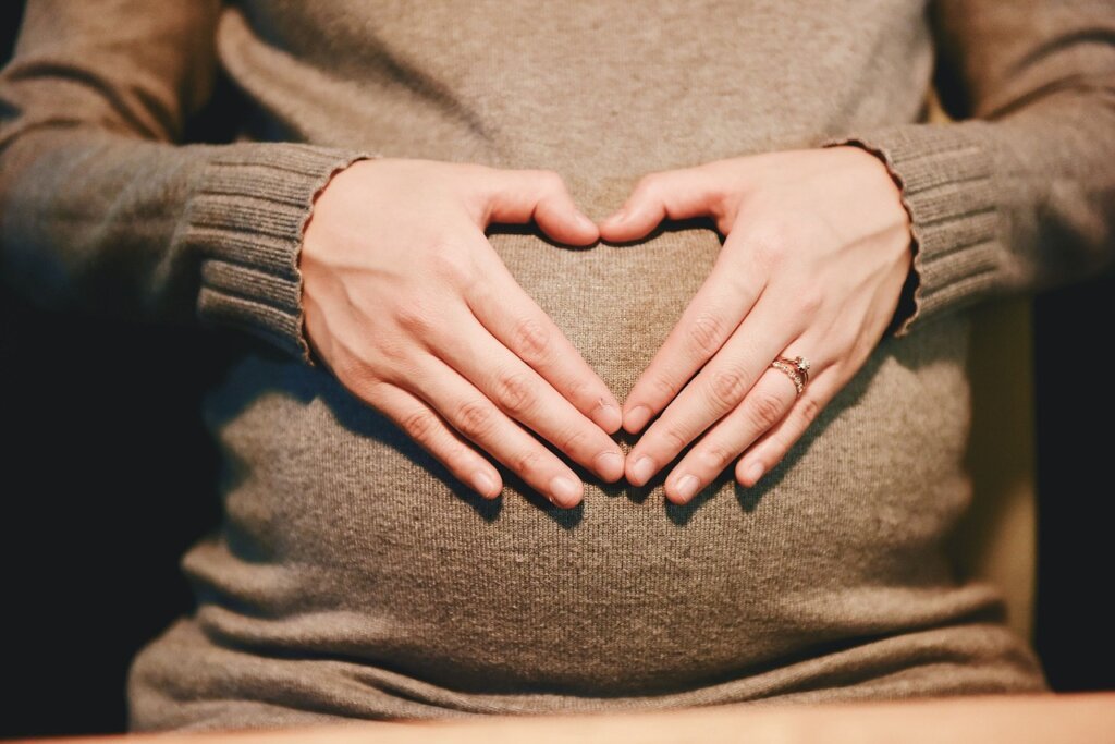 pregnant woman receiving national happiness card at hospital reception