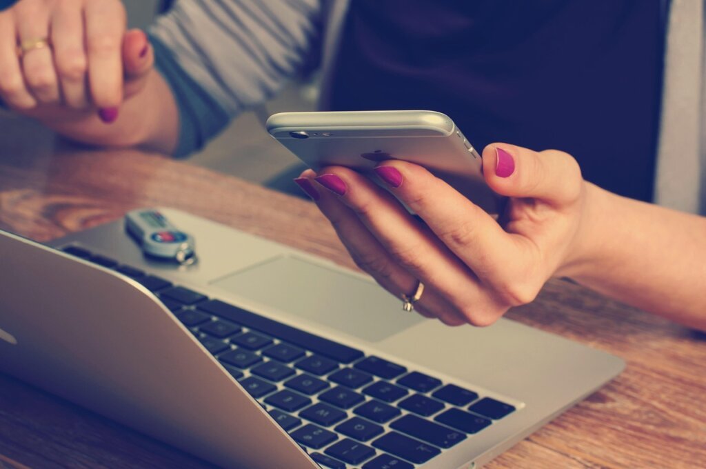 business owner checking bank account on smartphone with happy expression