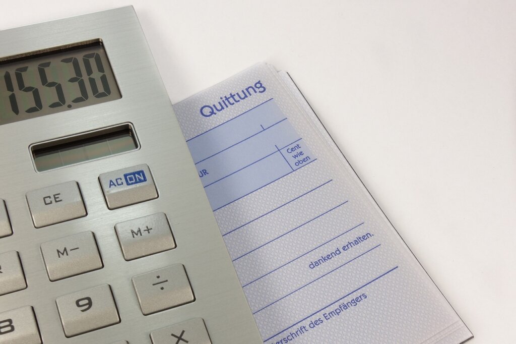 stressed small business owner looking at receipts with calculator